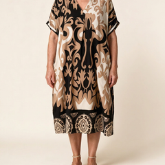 Robe midi Célestine en Noir Absolu, vue de face sur fond crème — coupe ample, col en V, bordure à médaillons