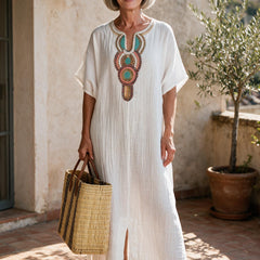 Robe longue Hortense en coton froissé blanc à col brodé, portée sur une terrasse du sud de la France