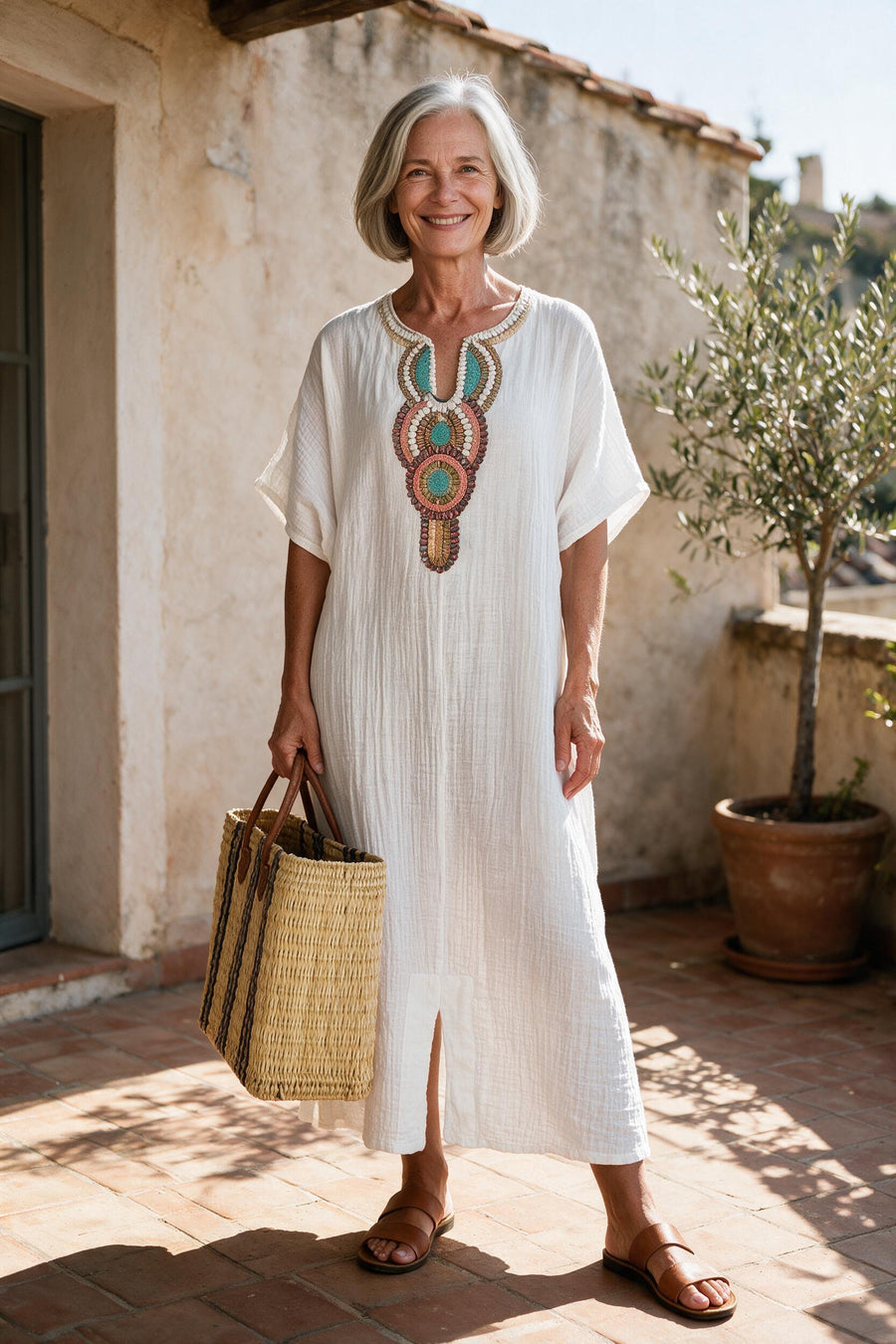 Robe longue Hortense en coton froissé blanc à col brodé, portée sur une terrasse du sud de la France