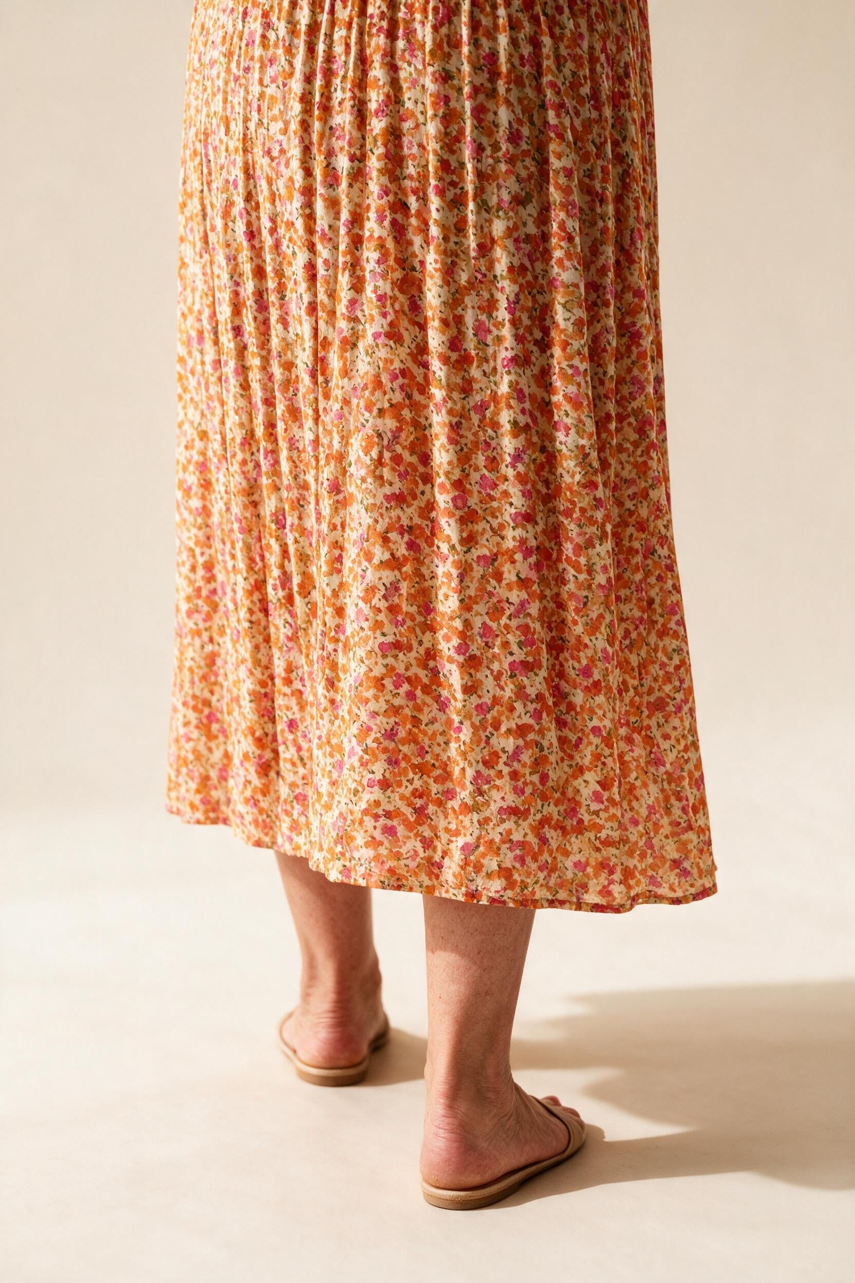 Détail de la jupe plissée et de l'imprimé floral