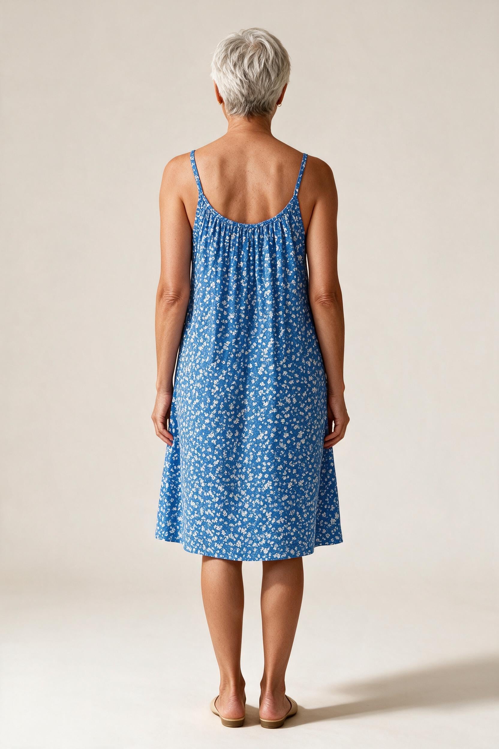 Robe Véronique vue de dos, fines bretelles droites et encolure arrondie, coloris bleu à petites fleurs blanches