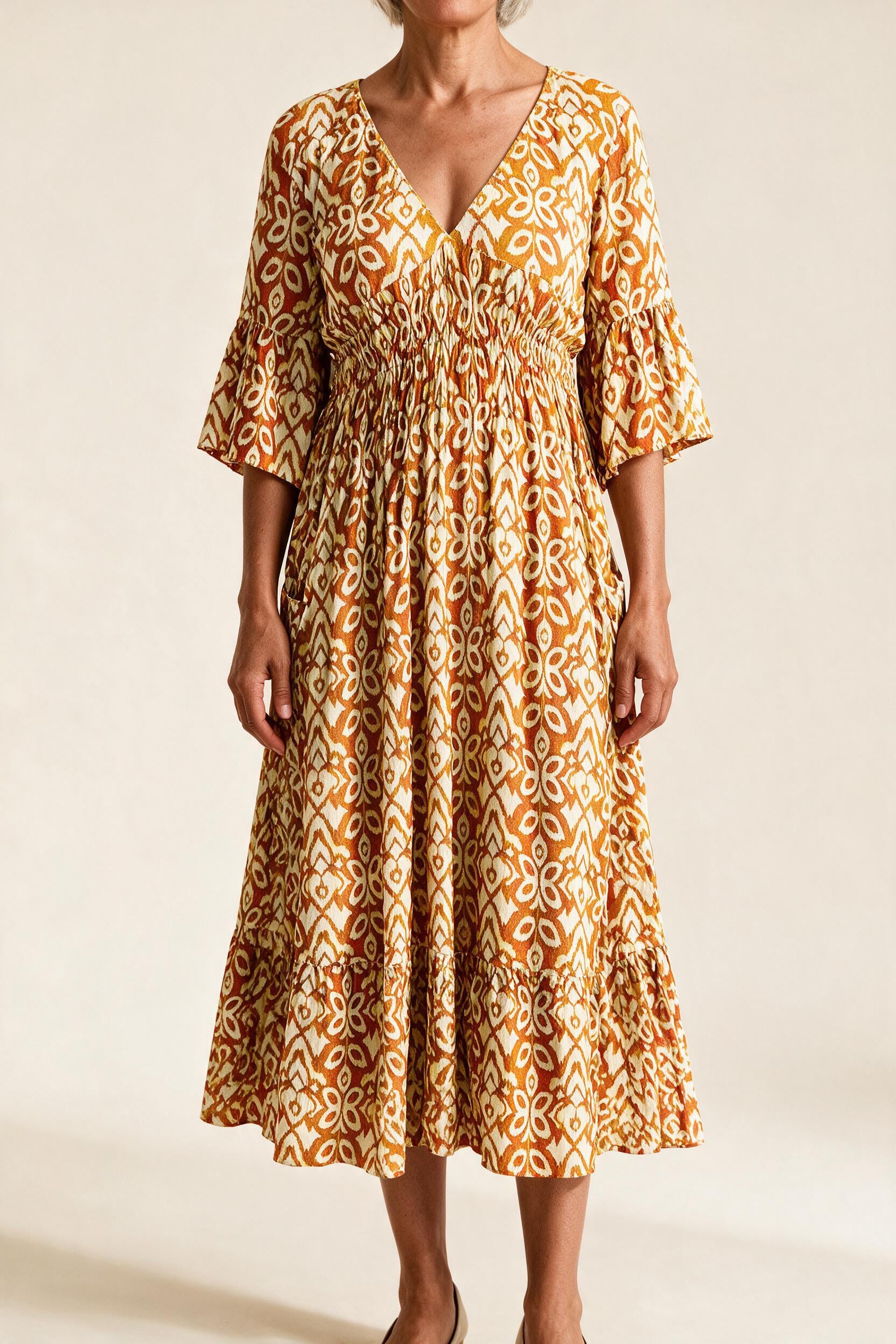 Robe midi Roseline, coloris jaune et orange — imprimé ikat, col en V, taille smockée et manches 3/4 à volant, vue de face