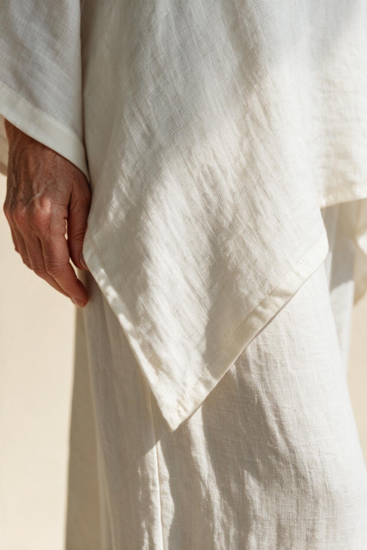 Détail de l'ourlet asymétrique et de la texture du tissu de l'ensemble Clémence