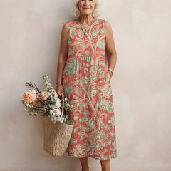 Robe midi Honorine sans manches à imprimé floral corail et vert sauge, portée main dans la poche