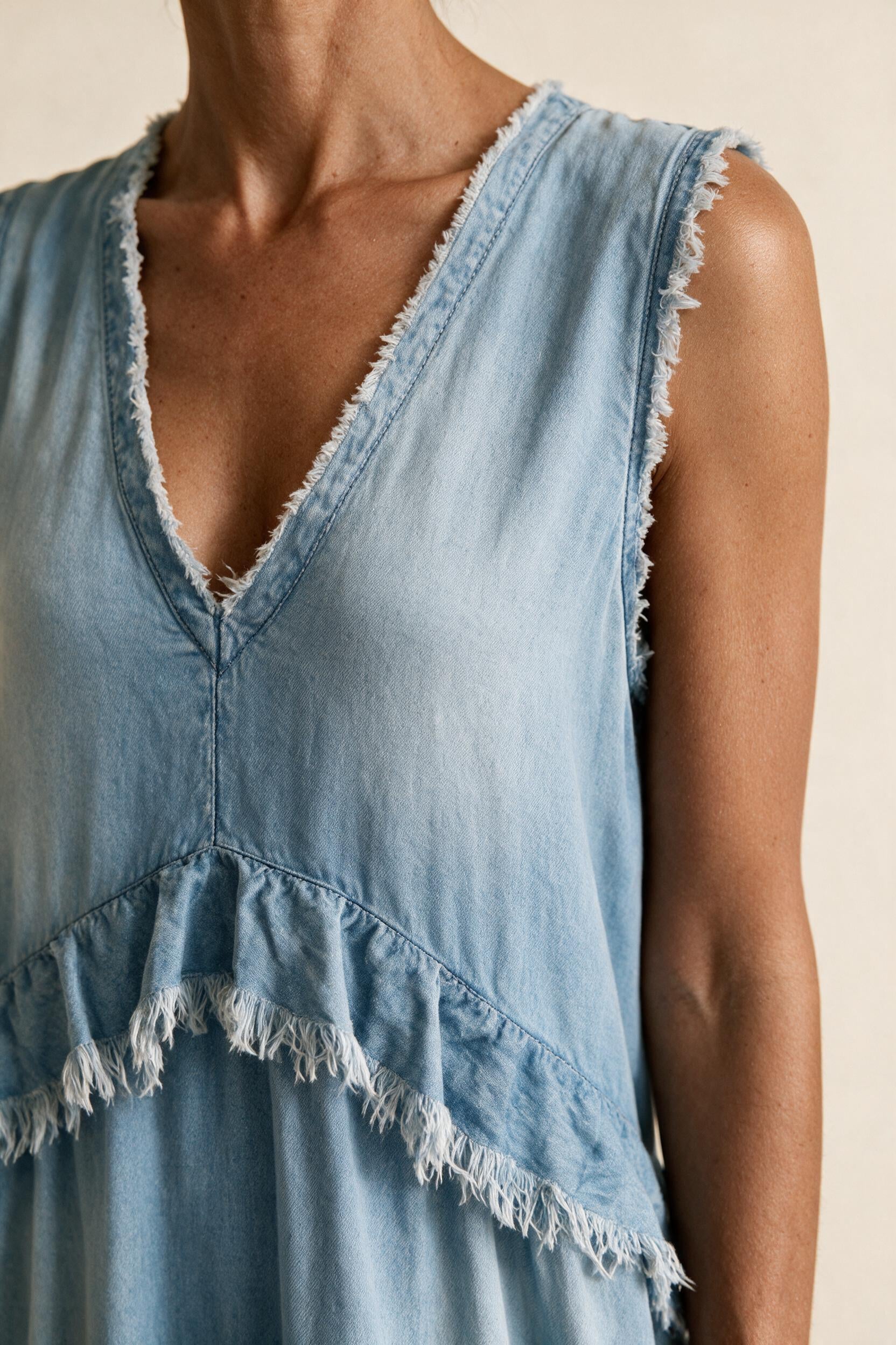 Détail du décolleté en V et de la finition frangée
